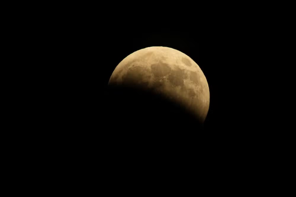 Eclipse lunar parcial é visto em diferentes partes do mundo